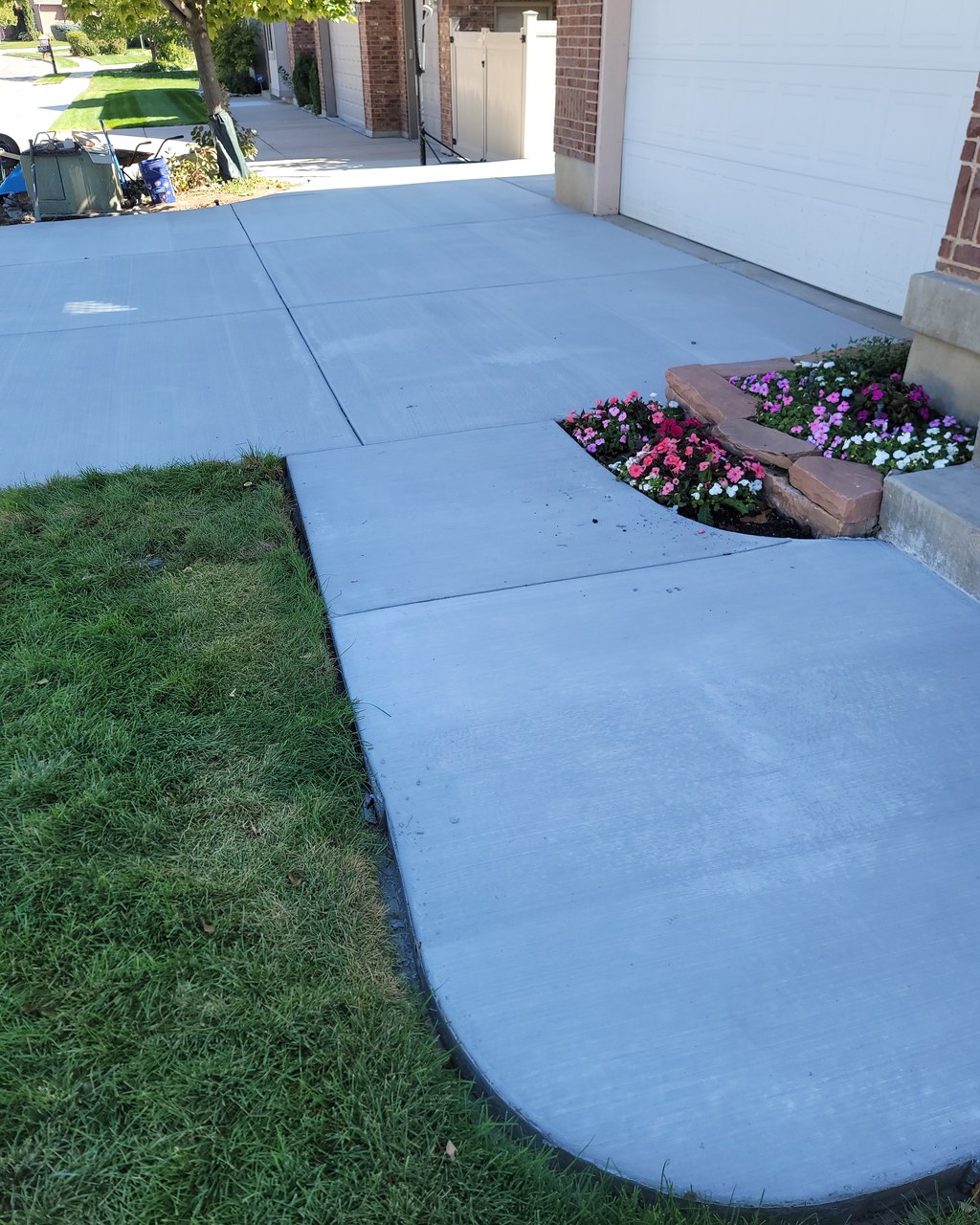 Finished Summit Landscape & Excavation backyard install in Utah with vinyl fence, mulched beds, river rock border, and arborvitae plantings