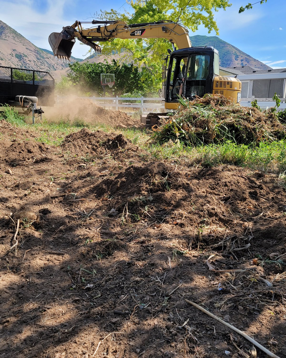 Excavator clearing yard dirt