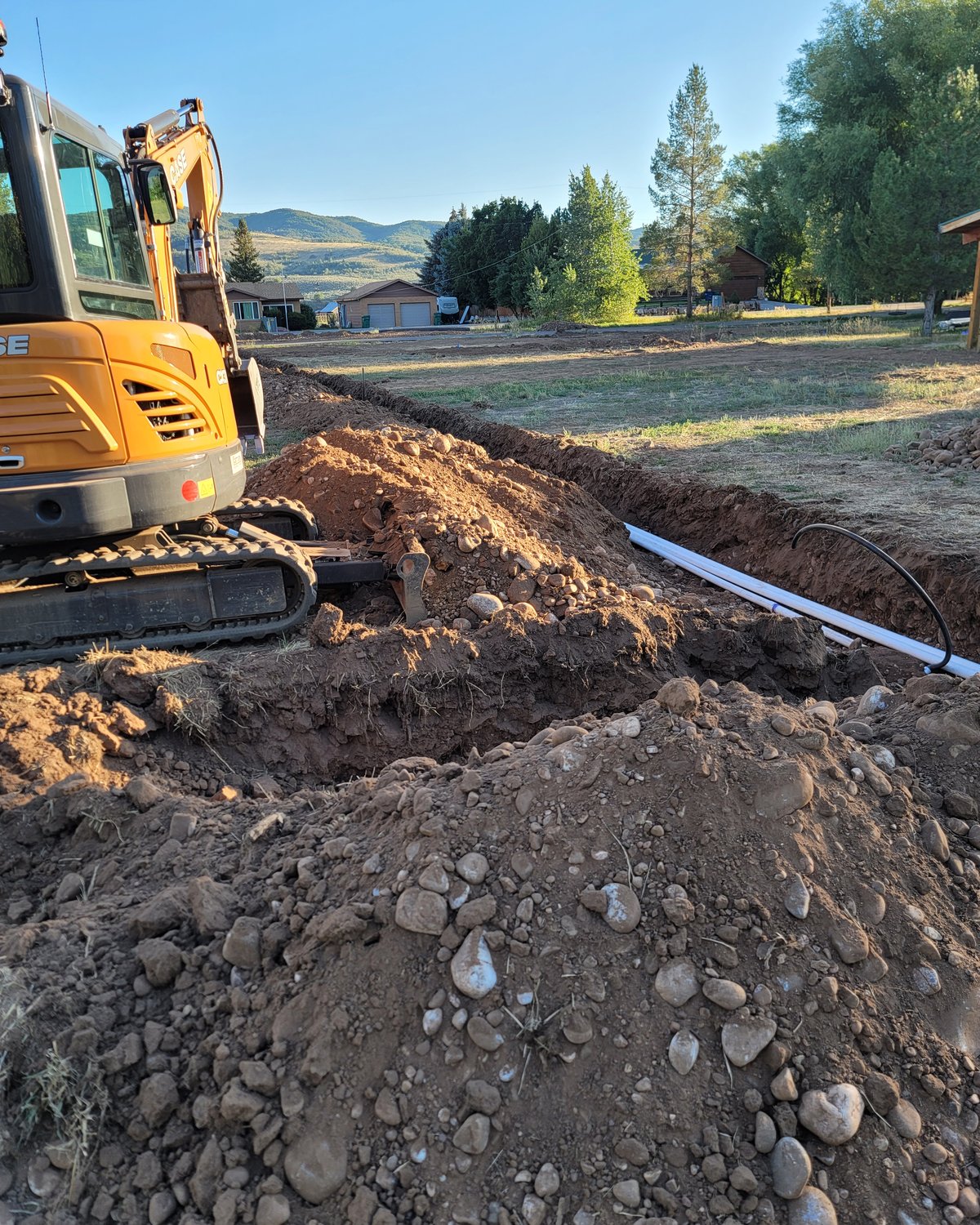 Excavator digging a utility trench