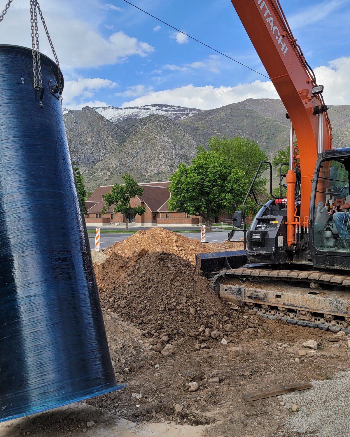 Excavator setting a manhole